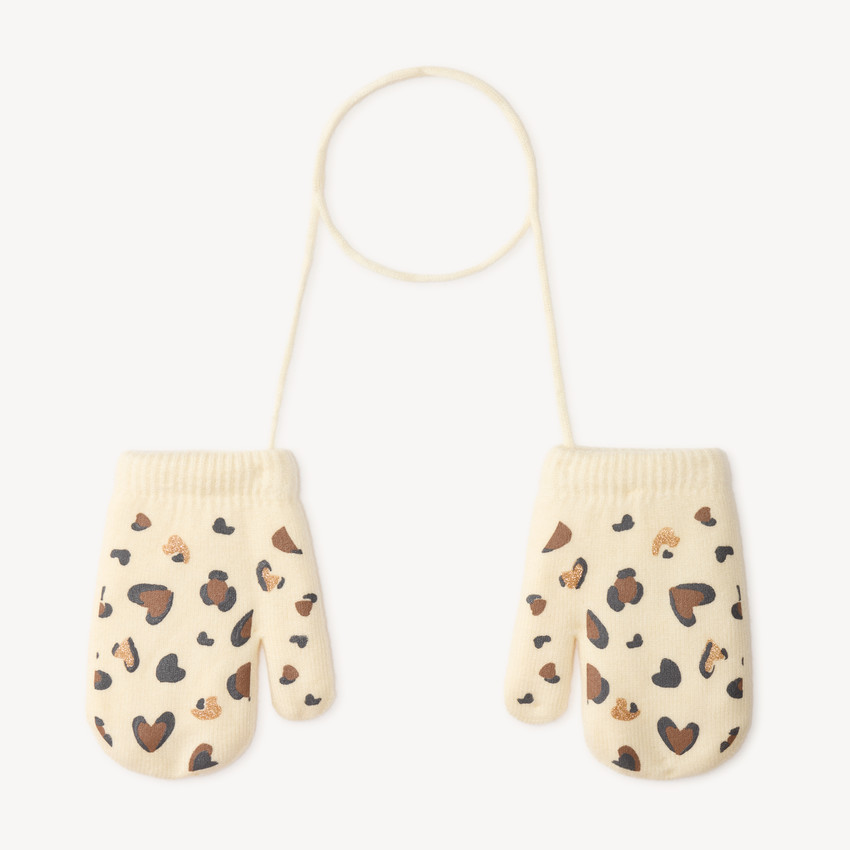 Moufles bébé en tricot à motifs cœurs reliées par un cordon