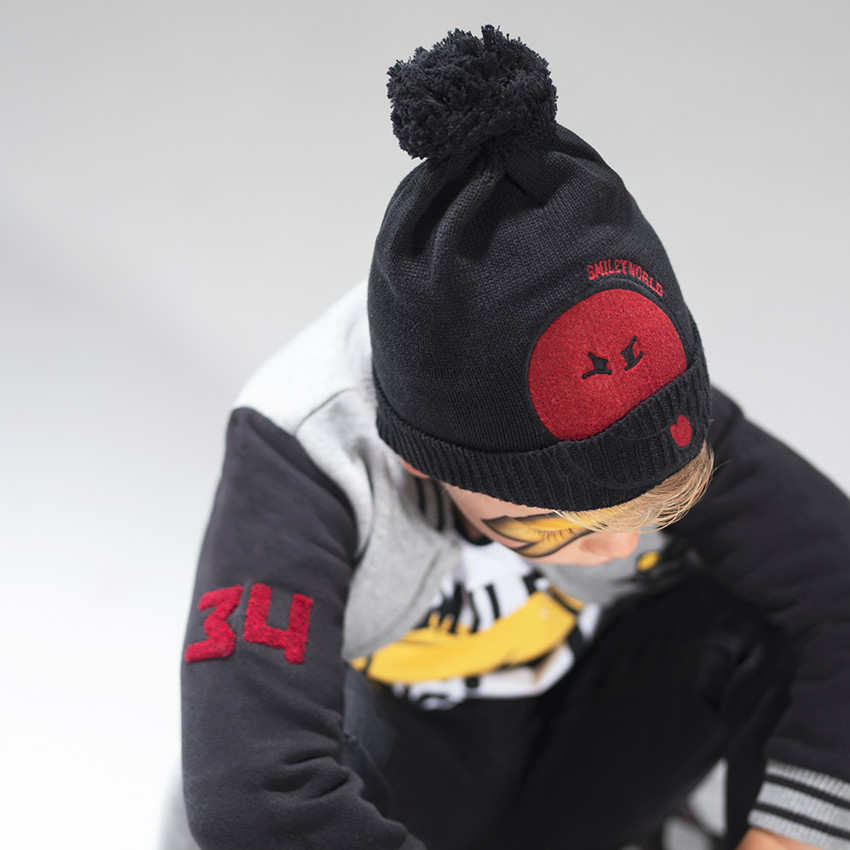 Bonnet en tricot avec pompon et patch Smiley en feutrine 