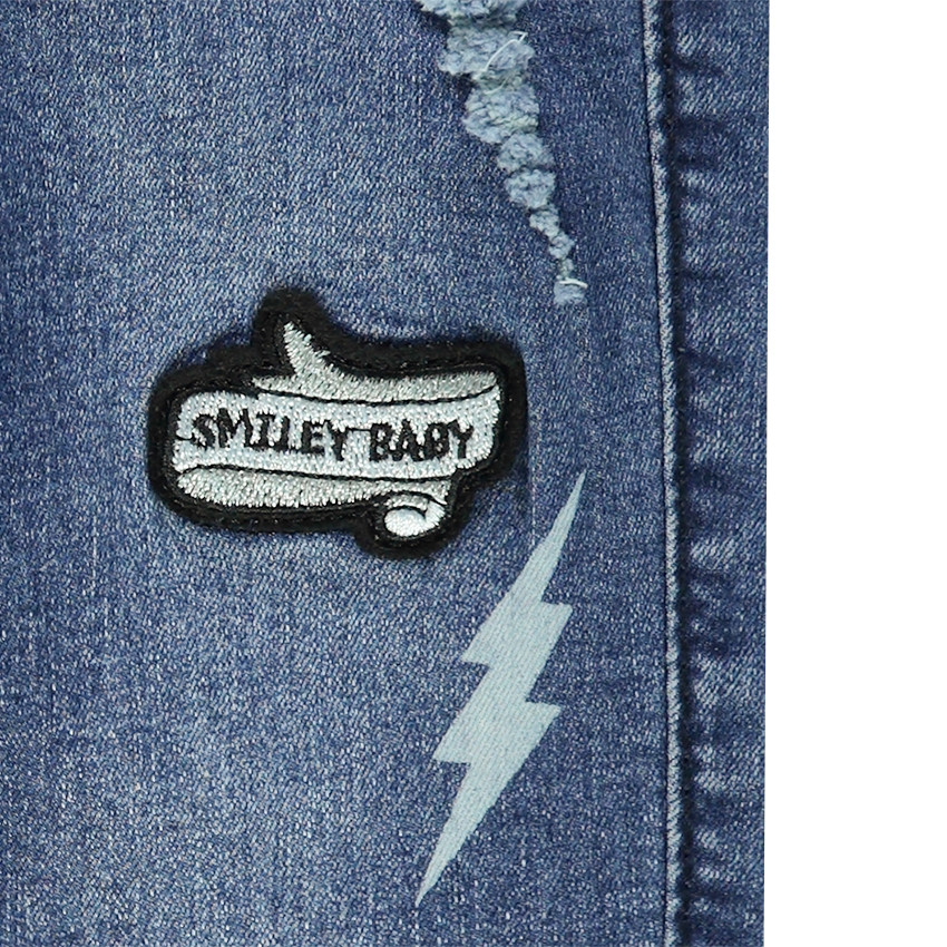 Jeans effet used avec badges Smiley 